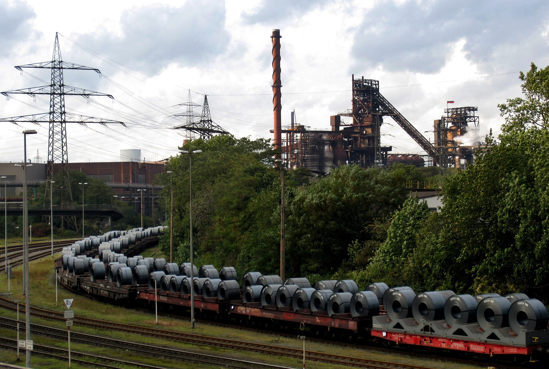 Blast furnace and stack of an industrial steelworks plant monitored for emissions, with visible instrumentation and steam